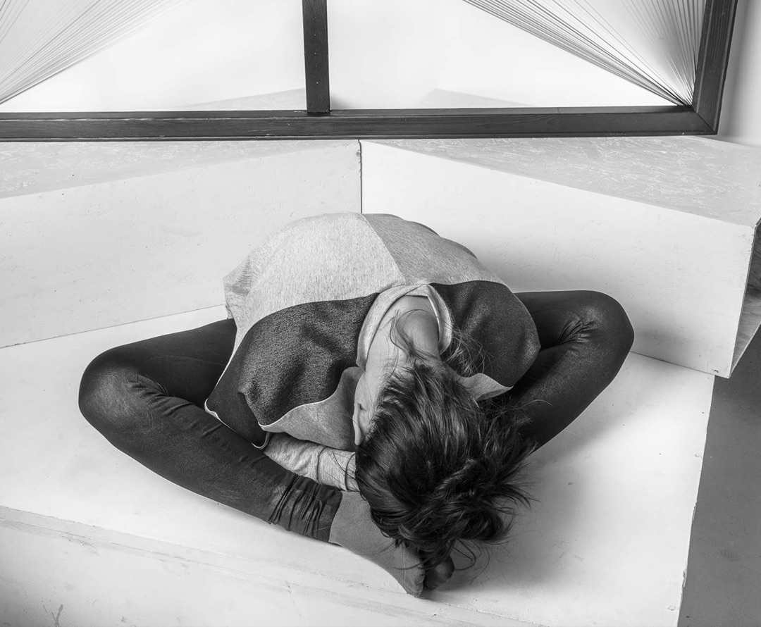 Overhead figure curled on geometric steps