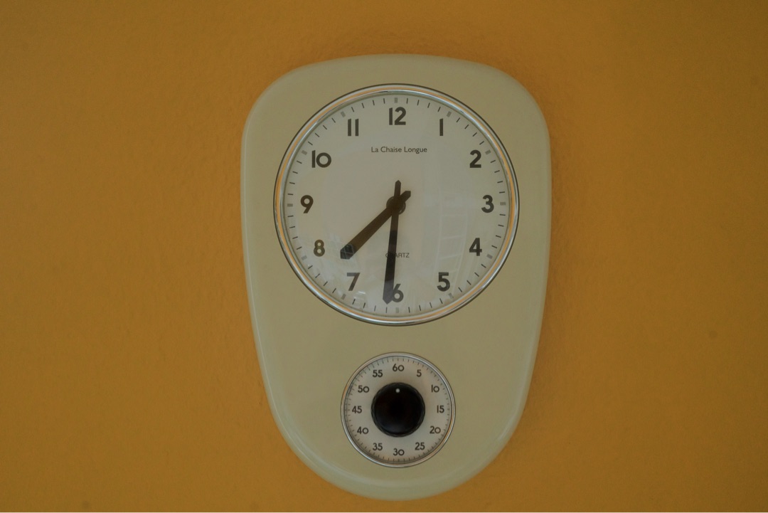 Retro wall clock on orange wall